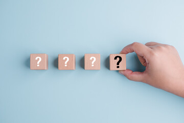 Wooden cube block in question mark mean what on cement table background, column of wooden blocks with question sign mark. copy space,FAQ frequently asked questions, Answer, Information