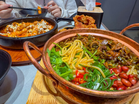 Korean cheese toppoki and Chinese oil dry noodles served with deep-fried chicken served in a restaurant in New Zealand