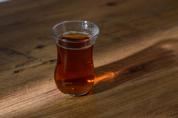 A warm cup of tea rests on a rustic wooden table, capturing cozy moments in the afternoon light