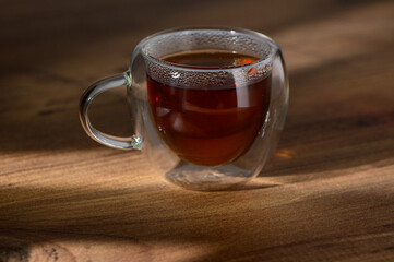 A warm cup of steaming tea resting on a wooden table in soft afternoon light
