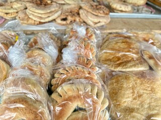 freshly Middle Eastern sweet bread with various variants of dates and sugar wrapped plastic.