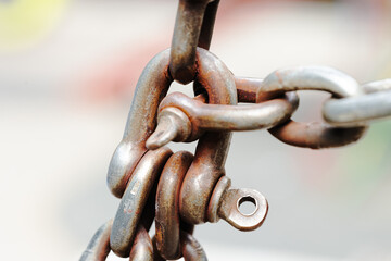 close up metallic aged old rusty chain and lock loop industrial cargo macro photography element with blurred background