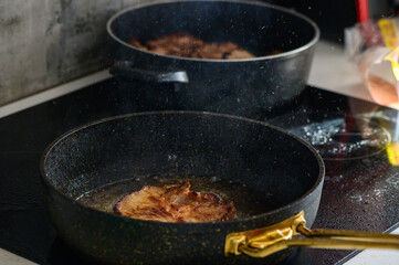 Sizzling pork chops frying in golden oil on a modern stovetop in a cozy kitchen setting at home