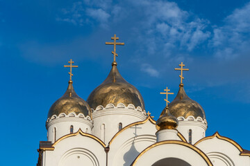 Golden domes of snow-white church in name of Holy Apostle Andrew First-Called, stylized as ancient...