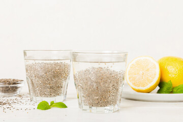 Healthy breakfast or morning with chia seeds lemon and mint on table background, vegetarian food, diet and health concept. Chia pudding with lemon and mint
