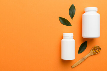 supplement pills with medicine bottle health care and medical top view. Vitamin tablets. Top view mockup bottle for pills and vitamins with green leaves, natural organic bio supplement, copy space