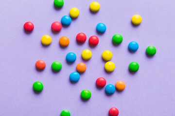 Mixed collection of colorful candy, on colored background. Flat lay, top view. frame of colorful chocolate coated candy