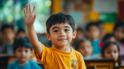 Smiling southeast asian boy raising his hand in a classroom setting