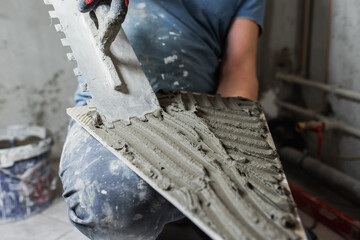 Laying porcelain tiles in the bathroom - floor tiling in a damp room - tiler workplace