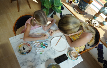  A young mother and her daughter enjoy a creative art session at home 