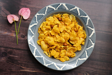 Maka Chivda is a Maharashtrian snack made with popped corn kernels, roasted peanuts, curry leaves, and spices. It offers a mix of sweet, salty, and spicy flavors, perfect for festive times or a crunch