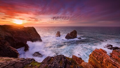 Obraz premium Sunset Over a Rocky Coastline With Dramatic Cliffs and Crashing Ocean Waves, Captured With Vibrant Orange and Pink Skies for a Stunning Seaside Nature Landscape