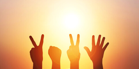 Happy new year 2025. Silhouette of four hands with 2025 symbol at fantastic sunrise or sunset sky...