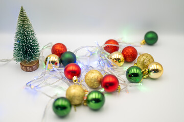 Capture the magic of the holidays with this captivating image of colorful Christmas ornaments nestled amongst twinkling fairy lights. 