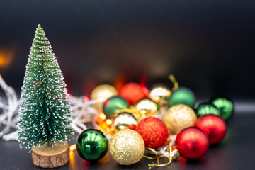 Embrace the festive spirit with this charming Christmas image featuring miniature Christmas trees nestled amongst colorful ornaments and sparkling fairy lights.