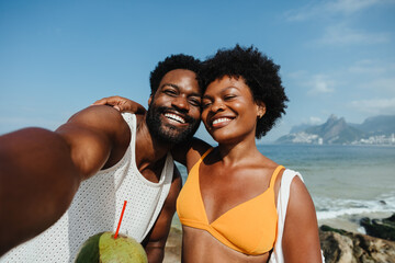 Happy parents taking a selfie at Ipanema Beach on holiday