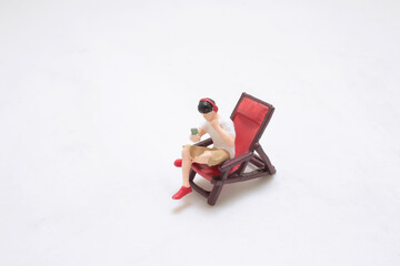 Miniature Figure Playing smart phone on a Chair