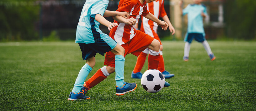 Boys Play Soccer Match on Green Grass. Running Youth Football Players. Kids Playing Football Soccer Game on Sports Field. Youth Soccer Tournament Teams Competition