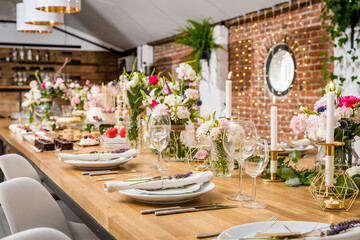 An exquisite dessert table adorned with a selection of artisanal pastries and cakes. The setup includes donuts, mousse cakes, mini cheesecakes, and layered desserts, all elegantly presented on rustic 