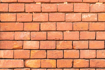 Aged red brick wall with signs of wear and tear. texture background