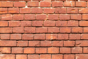 Obraz premium Aged red brick wall with signs of wear and tear. texture background