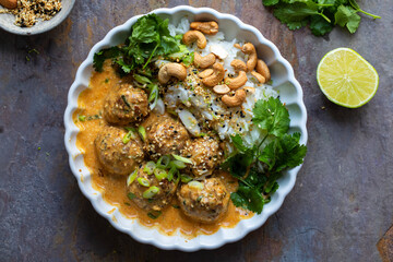 Turkey meat balls in thai curry sauce with rice, coriander and cashew nuts