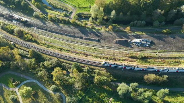 train driving along railway track public transport network belgium efficiency belgian system aerial drone panning shot view footage 
