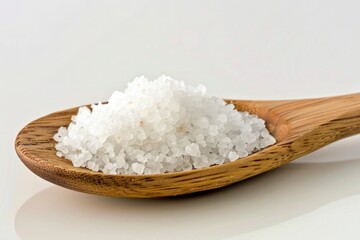 A wooden spoon filled with white salt sits on a table, ready for use