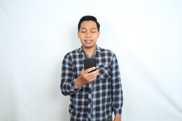 portrait of smiling asian man using smartphone wearing casual shirt isolated on white