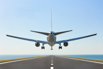 海の上の滑走路、青空にフライトする飛行機