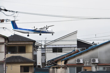 住宅地、電柱の上をジャンボジェットが飛ぶ、大阪の日常の景色