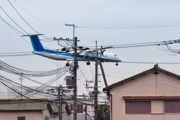 住宅地、電柱の上をジャンボジェットが飛ぶ、大阪の日常の景色