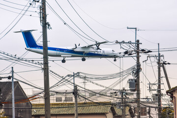 住宅地、電柱の上をジャンボジェットが飛ぶ、大阪の日常の景色