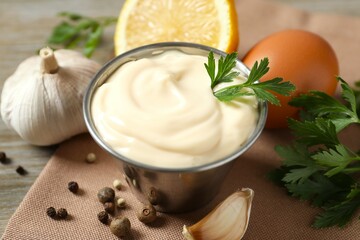 Bowl with mayonnaise and ingredients for cooking on the table 