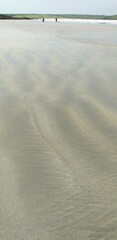 Tide is out showing the beautiful patterned sand on Perranporth beach in Cornwall