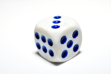 A white and blue playing stone lies on a white background.