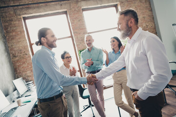 Photo of teamwork people working together shake hands deal comfortable modern office loft room interior indoors workspace