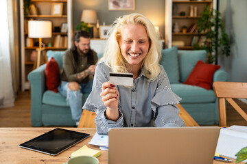 Young businesswoman using credit card and laptop to order and buy new digital tablet that got broken screen. Business female e-commerce online shopping for new device that got damaged.