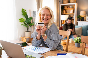 Young businesswoman using credit card and laptop to order and buy new digital tablet that got broken screen. Business female e-commerce online shopping for new device that got damaged.