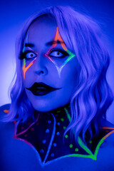 Portrait of a model wearing clown makeup with fluorescent eyewear