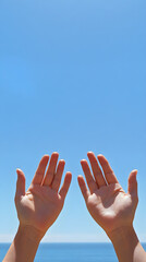 Open hands reach towards a bright blue sky, symbolizing hope and connection with nature in a serene and uplifting atmosphere