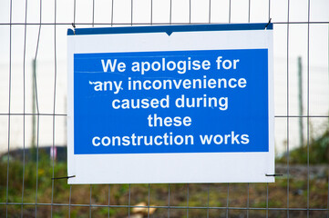 Construction site inconvenience apology sign on fence
