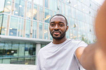 African American man with smartphone having video call on street in city. Guy blogger streaming chatting in social network. Man having virtual meeting vlog online chat outdoor Selfie webcamera view