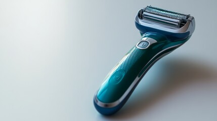 Obraz premium Close-up of a teal electric razor with a silver trim on a white background.