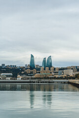 panorama of the city of baku on cloudy day with modern architecture towers standing on top of hill...