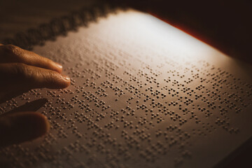 reading a Braille book in the dark for blind and visually impaired people
