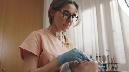 Professional beautician providing a skincare service to a female client in a beauty salon setting, displaying care and expertise.