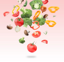 Many different fresh vegetables in air on light red gradient background