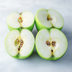 Vibrant green apples cut in half, revealing a juicy interior with seeds, ready for a refreshing snack or recipe