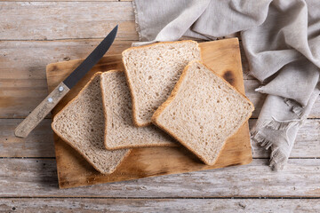 Healthy wholemeal bread slices on wooden table. Top view